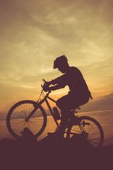Healthy lifestyle. Silhouette of bicyclist riding the bike at seaside.