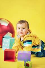Cheerful boy playing toy bricks