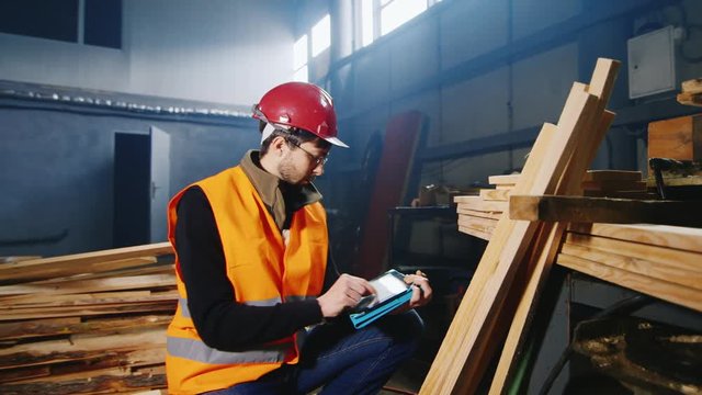 Carpenter working with the tablet: producing records of wooden billets