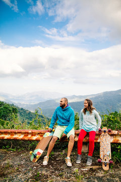 couple with longboard and skateboard travel in tropcis of Asia