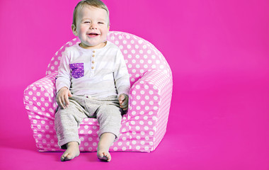 Little cute boy in the pink room