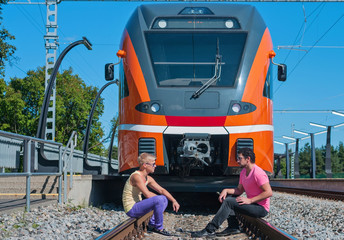 Young trendy guys in front of train