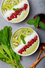 Green smoothie bowl topped with  fruits and shredded coconut