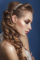 Fototapeta premium Beautiful bride with fashion wedding hairstyle - on blue background.Closeup portrait of young gorgeous bride. Wedding. Studio shot.Beautiful bride portrait 