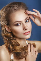 Fototapeta premium Beautiful bride with fashion wedding hairstyle - on blue background.Closeup portrait of young gorgeous bride. Wedding. Studio shot.Beautiful bride portrait 