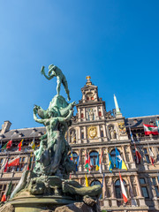 Fototapeta na wymiar City Hall and Brabo fountain on the Great Market Square of Antwerp, Belgium, under clear blue sky in sunny weather day