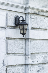 Old black iron lamp on stone wall of middle ages castle