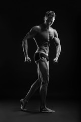 Bodybuilder man posing, showing perfect abs, houlders, biceps, triceps, chest