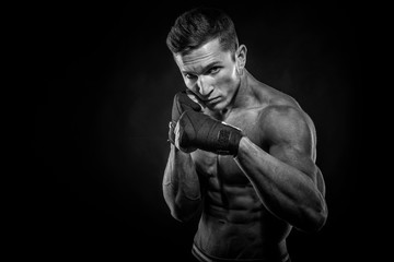 Fototapeta na wymiar Portrait of attractive kickboxer in the dark