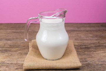 Milk glass jug on the wooden floor.