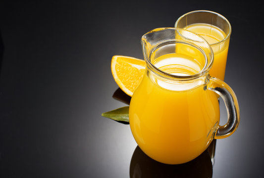 orange juice and fruit on black