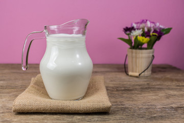 Milk glass jug on the wooden floor.