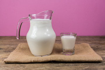 Milk glass jug on the wooden floor.