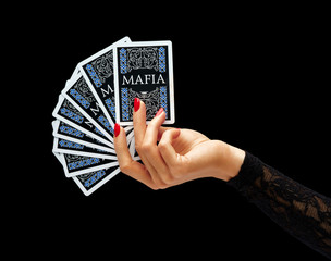 Womens hand holding playing cards isolated on black background. Business concept