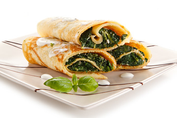 Crepes with spinach and feta cheese on white background 