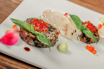 Delicious salmon tartare with red caviar on white plate