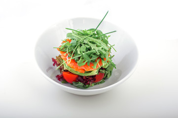 Fresh tartar with salmon, avocado, rucola and arugula on black white, close up