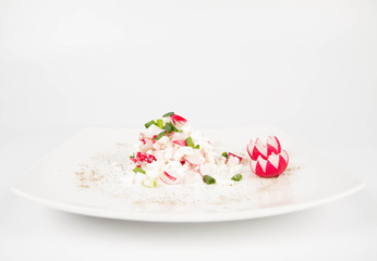 Cottage cheese with radish and chives on a white plate