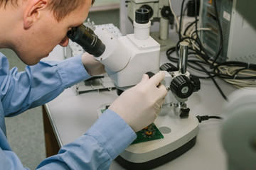 expert looks at the chip under the microscope