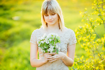 Beautiful portrait of a girl on the background of blossoming spring nature. Toned.