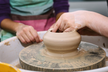 pottery. the teacher teaches the student work on the potter's wheel.