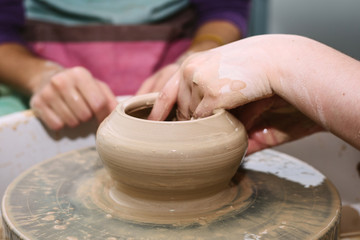 pottery. the teacher teaches the student work on the potter's wheel.