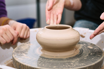 Fototapeta na wymiar pottery. the teacher teaches the student work on the potter's wheel.