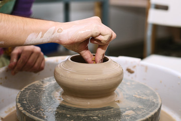 pottery. the teacher teaches the student work on the potter's wheel.