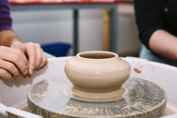 Fototapeta na wymiar pottery. the teacher teaches the student work on the potter's wheel