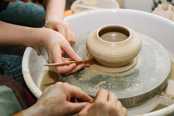pottery. the teacher teaches the student work on the potter's wheel.
