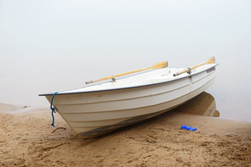 Fototapeta premium Boat on shore. Early morning fog