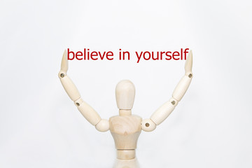 Hand writing believe in yourself with wooden persona on transparent wipe board.