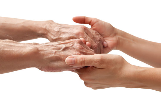 Hands of an elderly man holding the hand of a younger woman