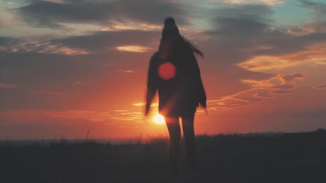 Happy girl jumping at sunset