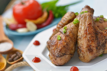 Appetizing fried chicken on a white plate, with spices. Close-up