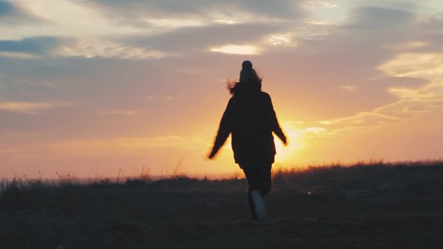 Happy girl jumping at sunset