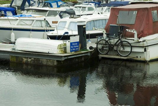 an image of moored boats one with a bicycle tied to the rear