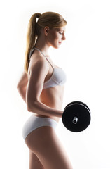 Young blond woman training with dumbbells