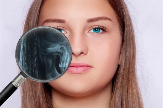 Roentgen screening with a magnifying glass, face of a young woman 