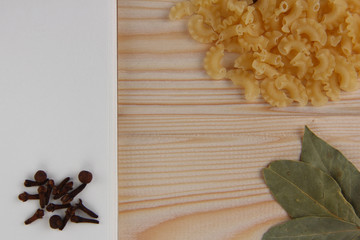 notebook with spices and noodles on wooden background