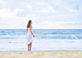 Fototapeta na wymiar Beautiful woman in a white dress on the beach