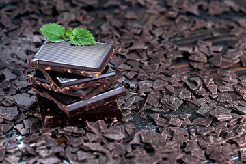 Broken dark chocolate and chocolate flakes on a wooden table