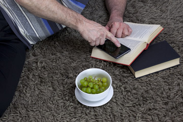 Man laying on a grey rug using his phone