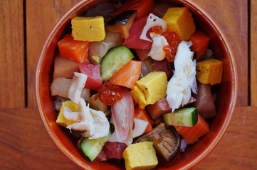 Bowl of chirashi sushi with mixed raw fish and salmon roe over rice