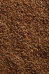 Pile of buckwheat seeds background, close up