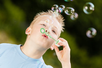 Child blowing bubbles outdoors