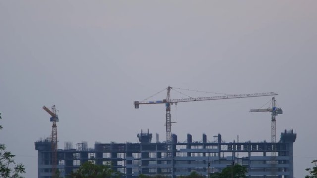 4k Time-lapse of Sunset Building construction with Crane at construction site 