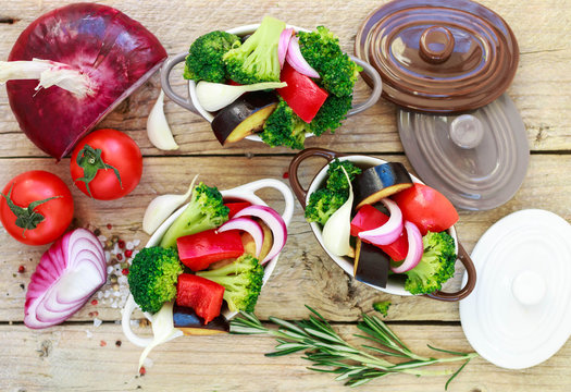 Raw fresh vegetables - broccoli, eggplant, peppers, tomatoes, onions, garlic in portion pots. Preparation of the garnish
