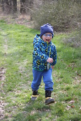 Fröhlicher Junge rennt durch den Wald