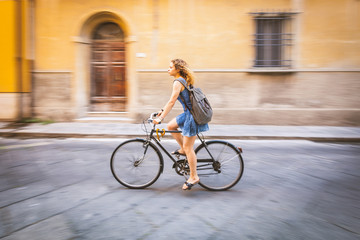 Fototapeta na wymiar Girl cycling in the city, panning shot
